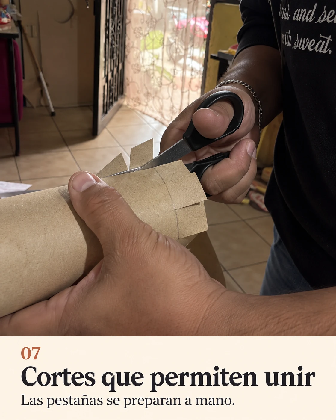 Manos cortando pestañas en una pieza cilíndrica de cartón