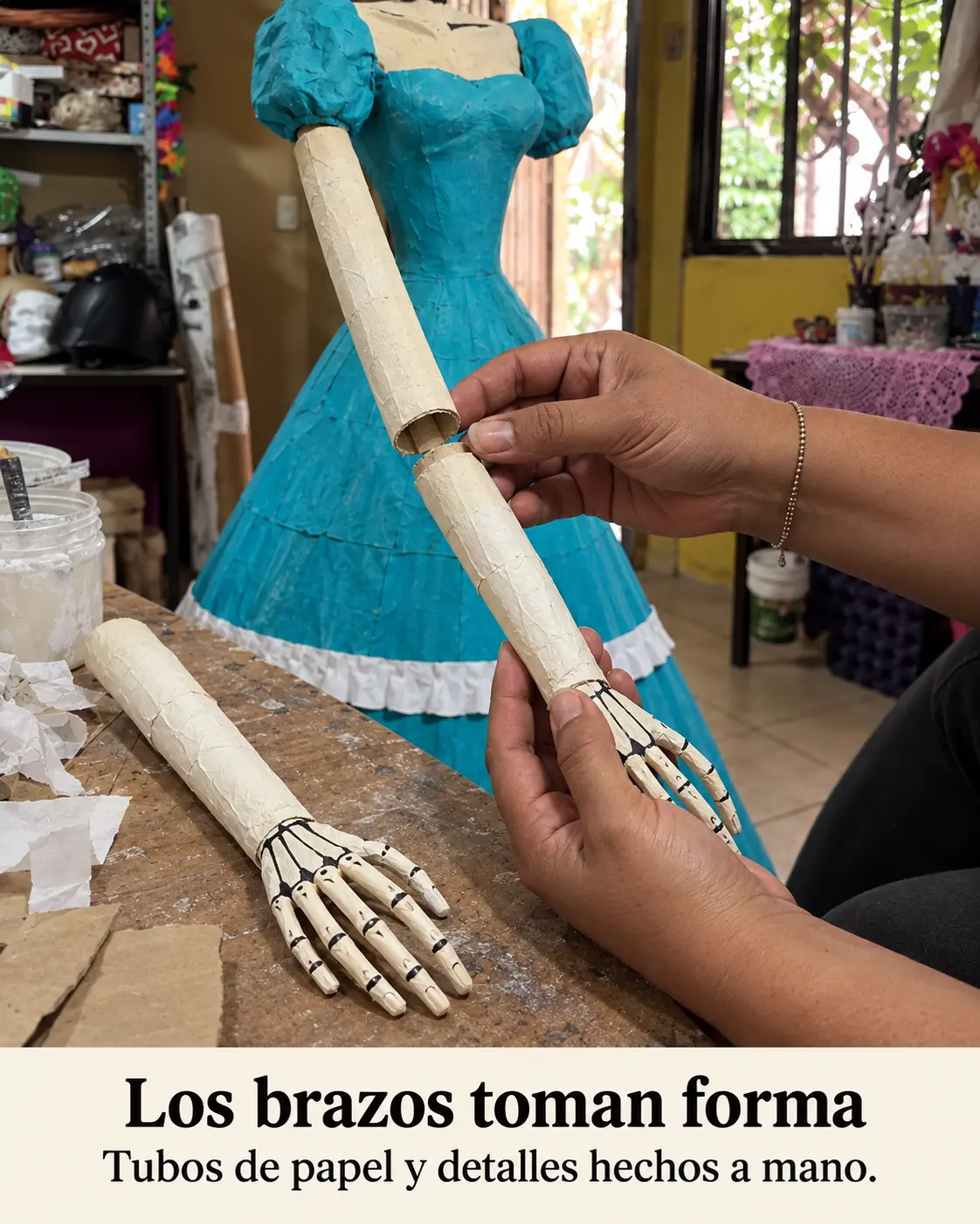 Manos modelando con papel los brazos de la catrina artesanal