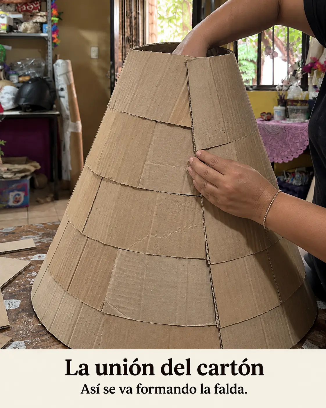 Manos uniendo piezas de cartón para formar la falda de una catrina